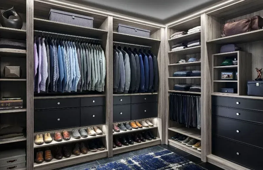 A walk in closet filled with lots of clothes and shoes.