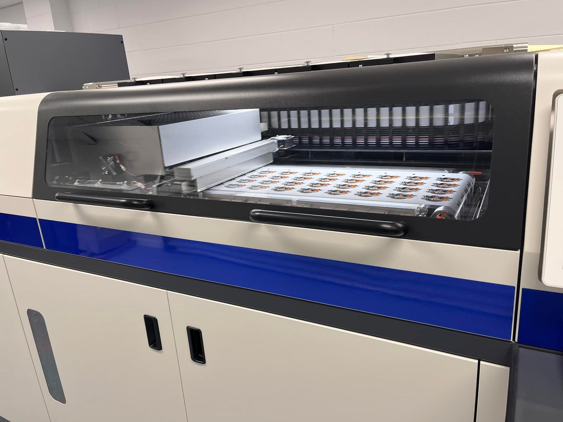 A machine with a blue and white stripe on the side is sitting on a counter — Aldine Printers in Bungalow, QLD