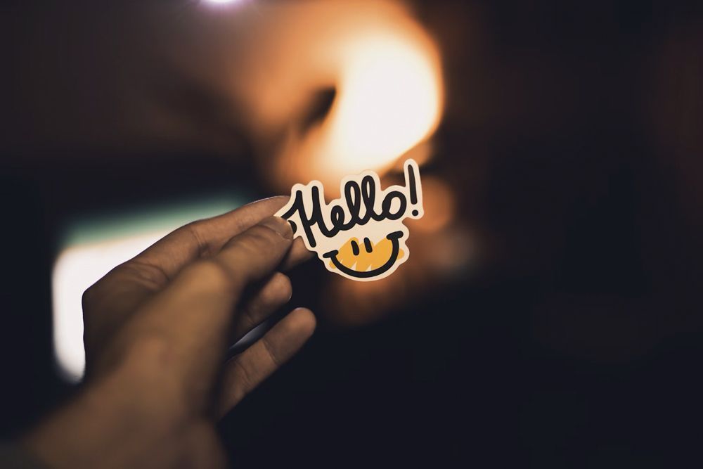 A Person is Holding a Sticker That Says Hello With a Smiley Face — Aldine Printers in Bungalow, QLD