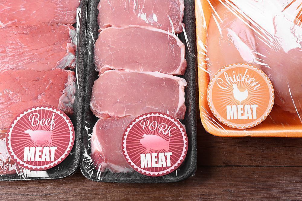 A Tray of Beef, Pork, and Chicken Meat on a Wooden Table — Aldine Printers in Bungalow, QLD