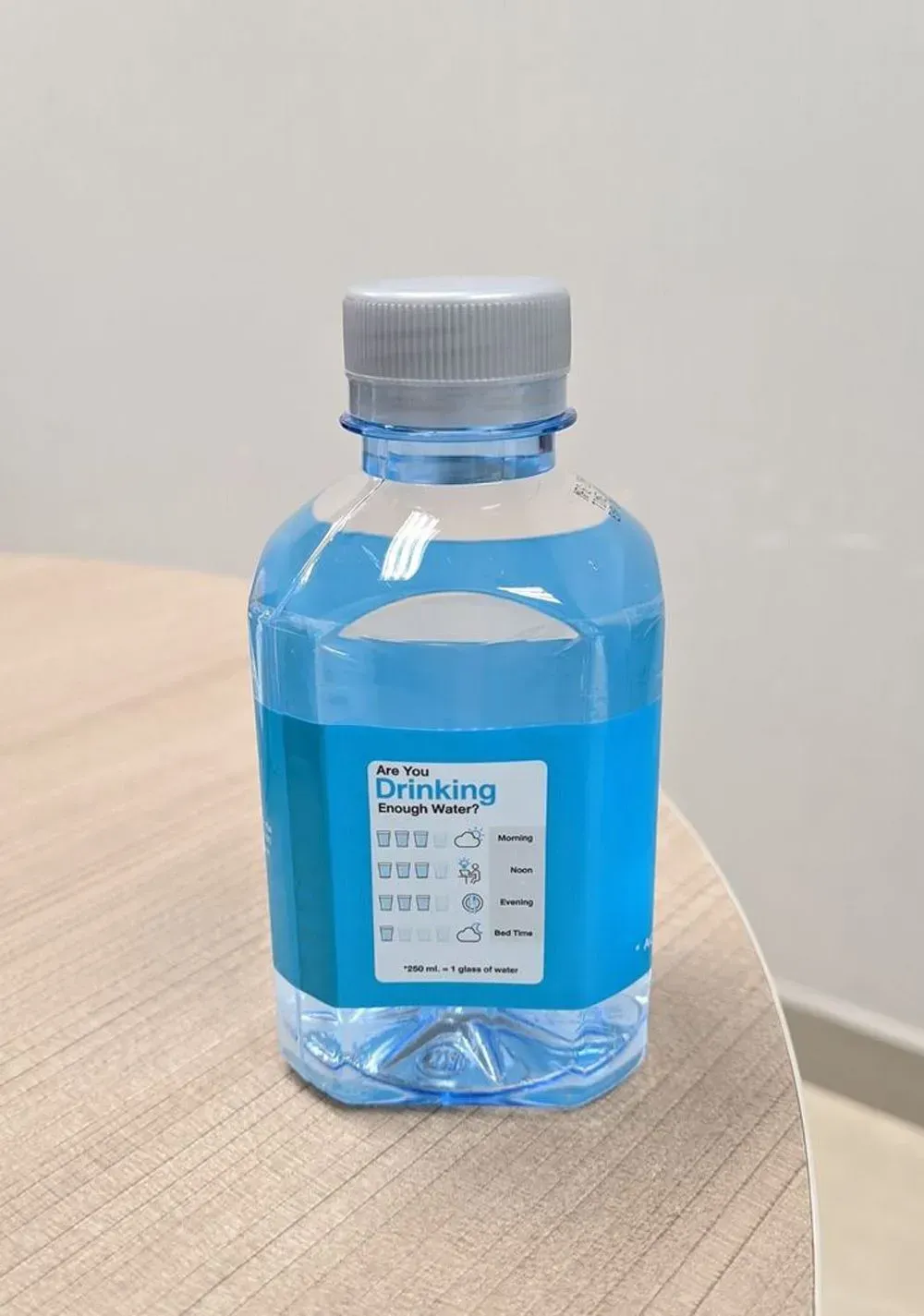 A Bottle of Drinking Water Sits on a Wooden Table — Aldine Printers in Bungalow, QLD