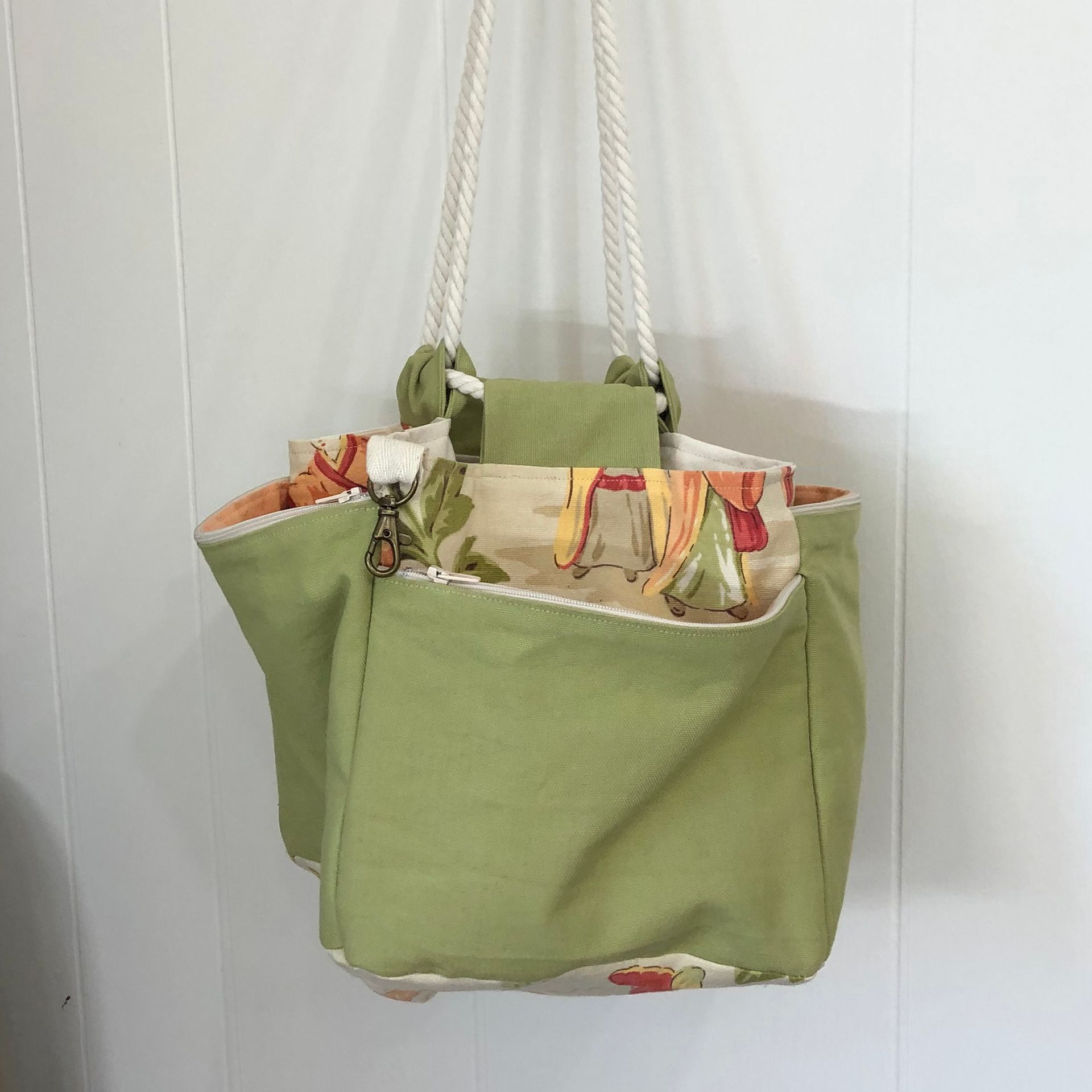 Green and floral fabric drawstring bag open, sitting on a patterned white surface.