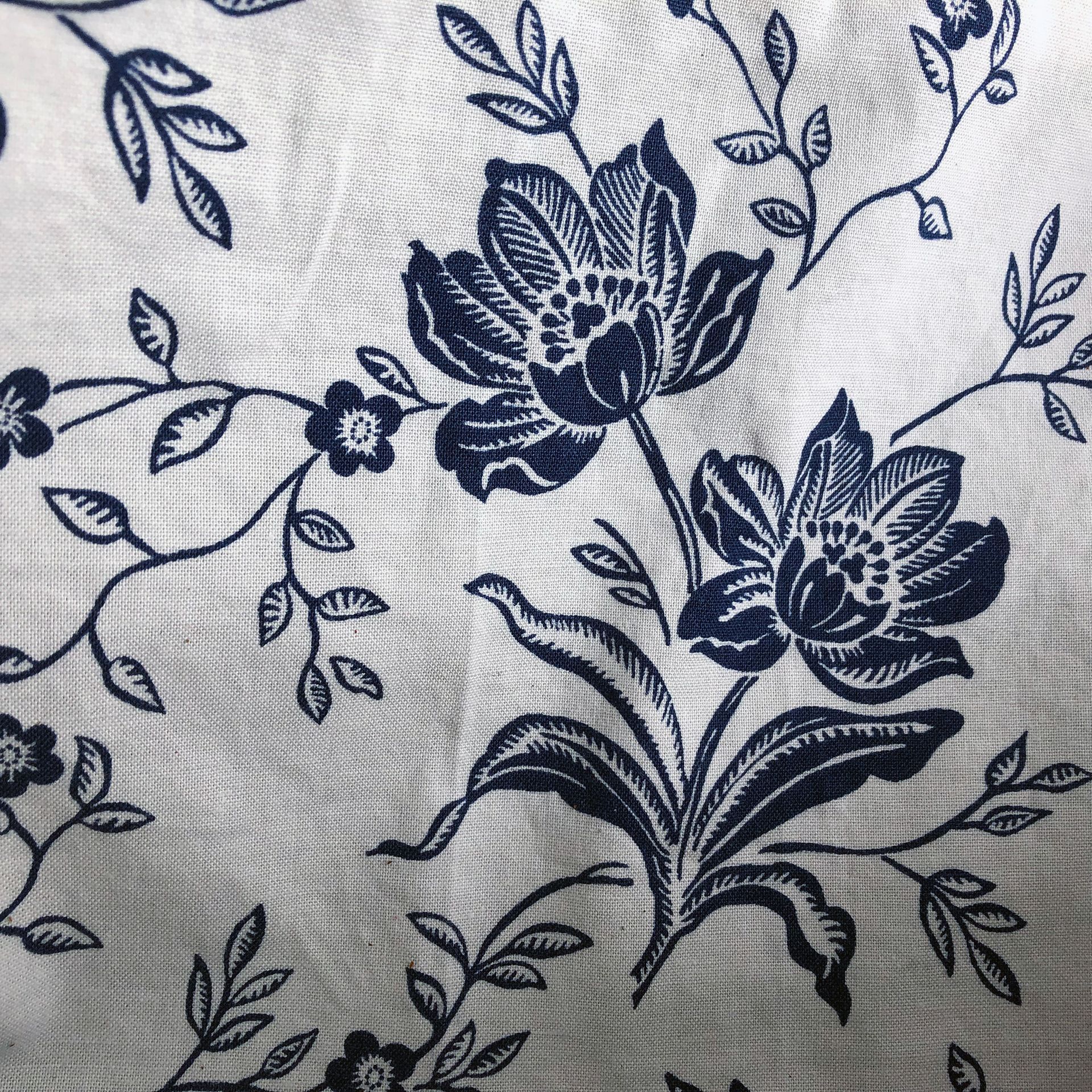 Navy blue tote bag hanging on a white wall.