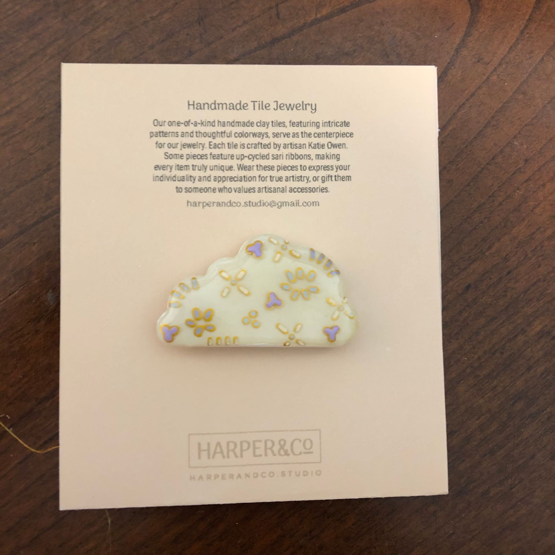 Cloud-shaped handmade clay jewelry on a pink card. White, gold, and purple floral design.