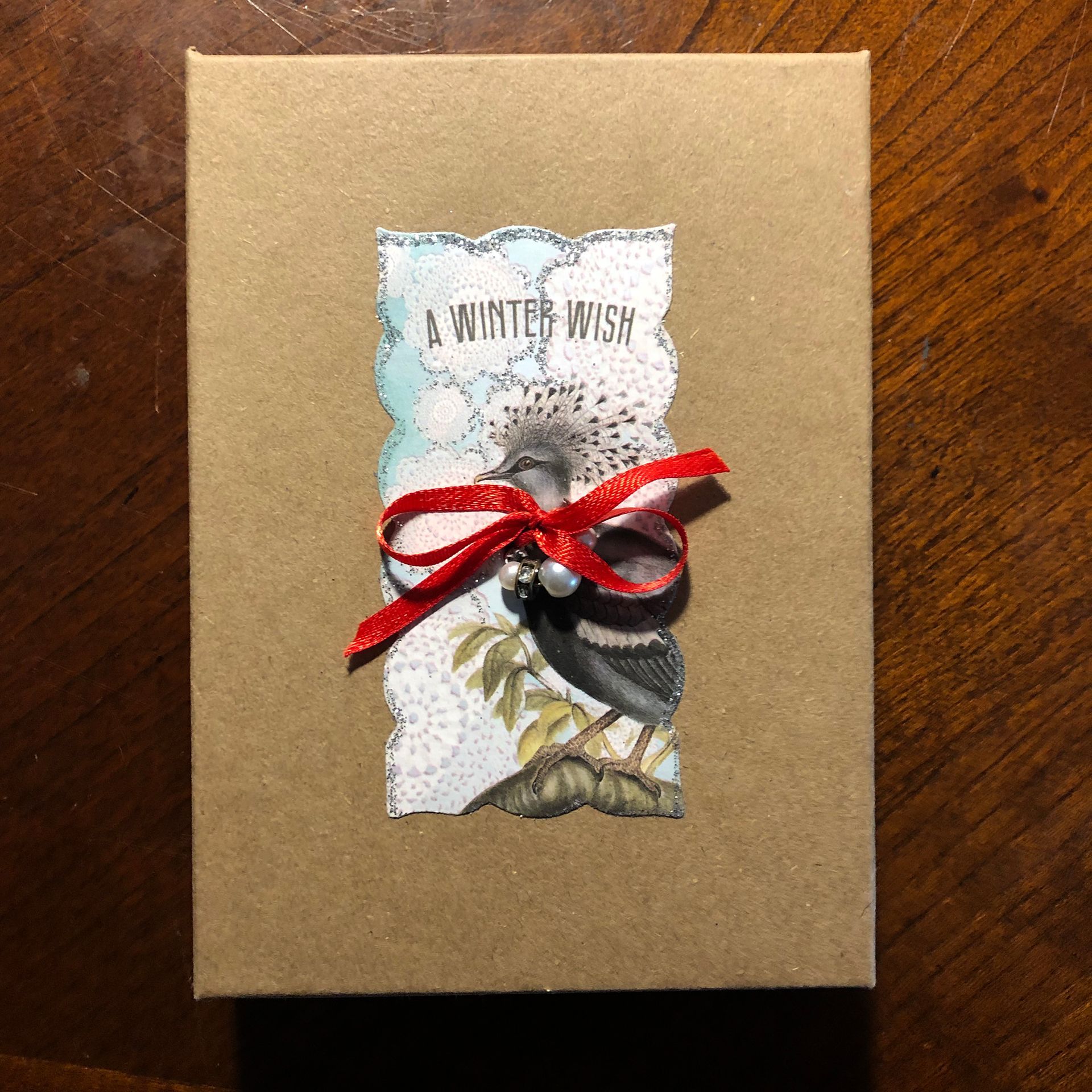 Brown box with winter bird collage and red ribbon. 
