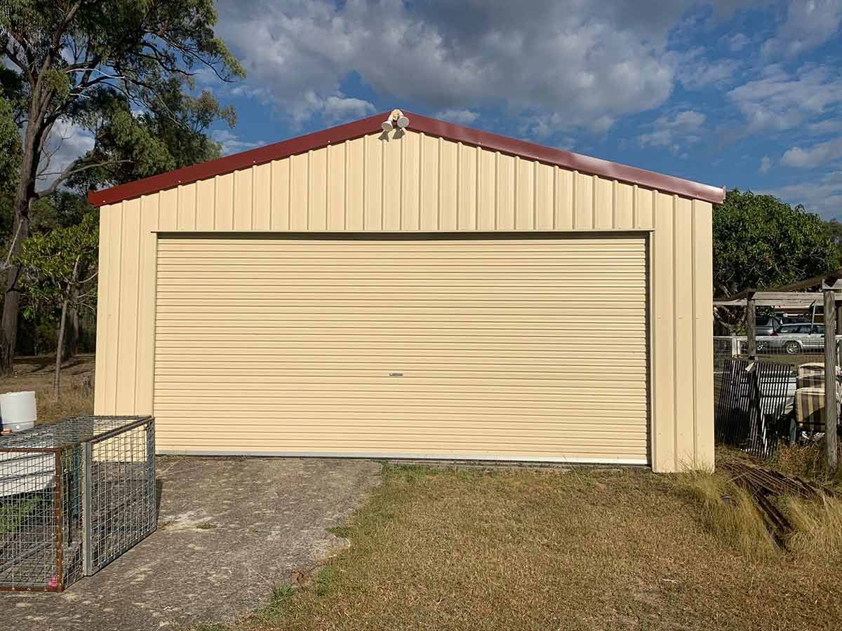 A Yellow Garage With a Red Roof and a Roller Door — Ben McLennan Constructions in Grafton, NSW