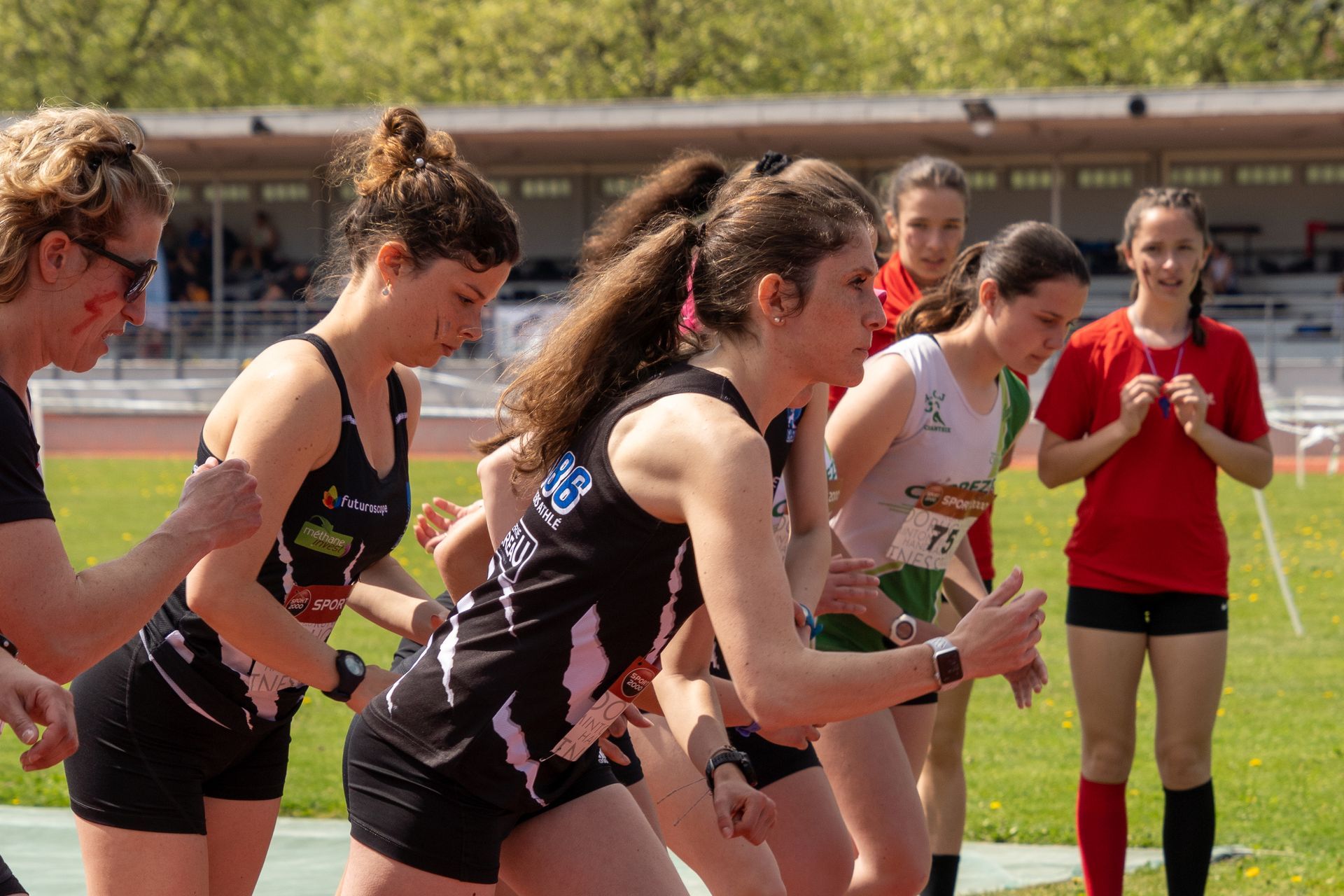 Marcheuse au départ d'une course sur piste. En extérieur, par une journée ensoleillée. 