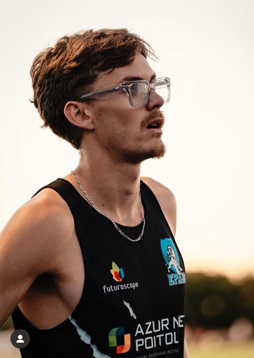 Mathias Pillot dans son maillot de club noir et blanc, levant les yeux avec une expression concentrée sur une piste.