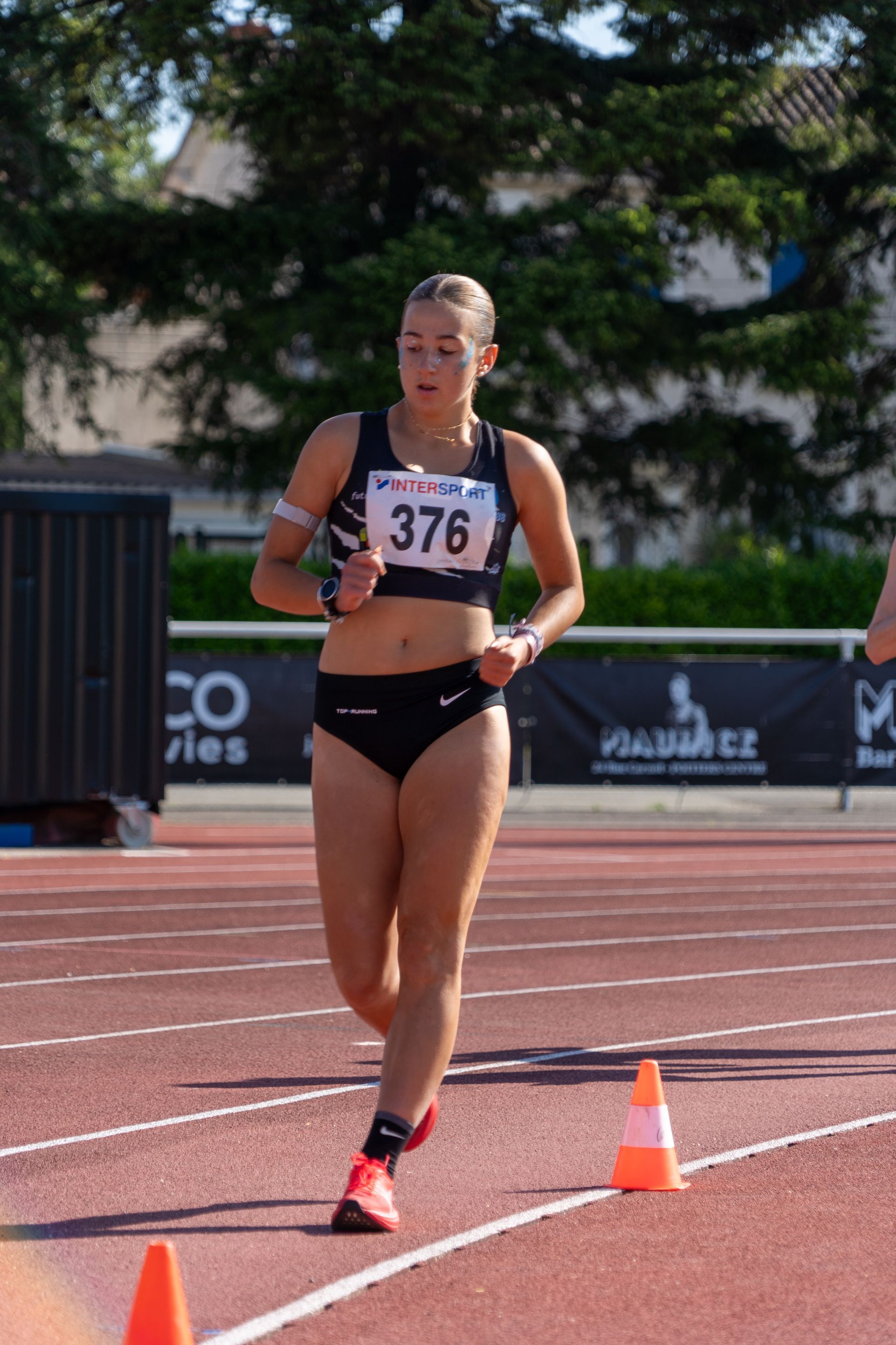 Athlète féminine,  marchant sur une piste, portant une tenue de sport noire, concentrée. Daphné Gateau-Fernez. 