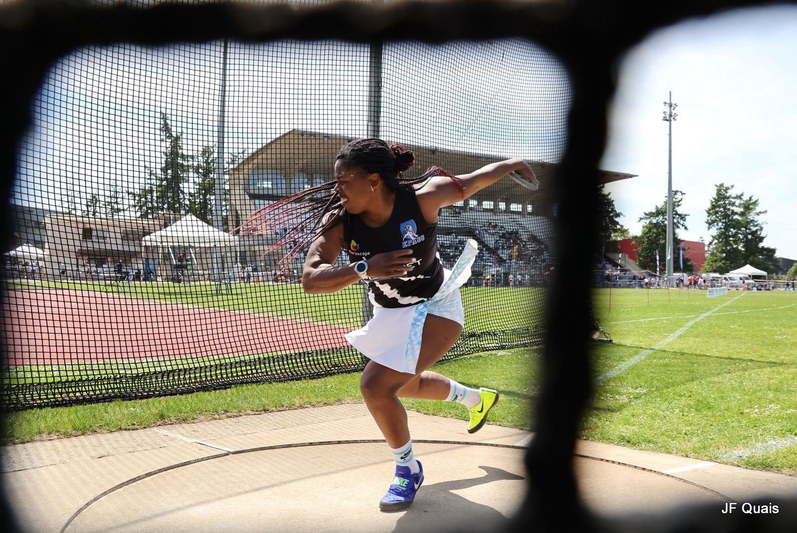 Une femme en tenue de sport lançant un disque lors d'une épreuve d'athlétisme, Sibylle Retour. 
