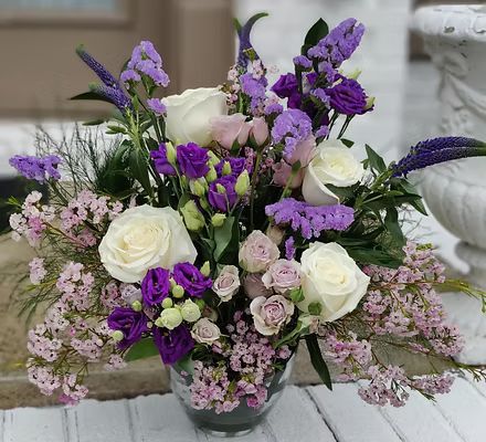 A vase filled with purple and pink flowers is sitting on a table.