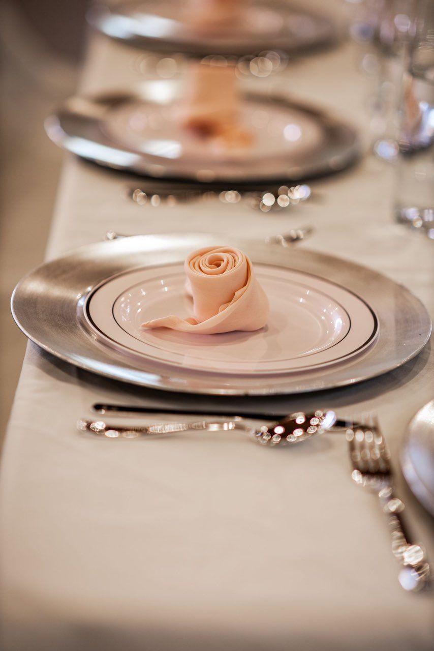 A close up of a plate with a napkin on it on a table.