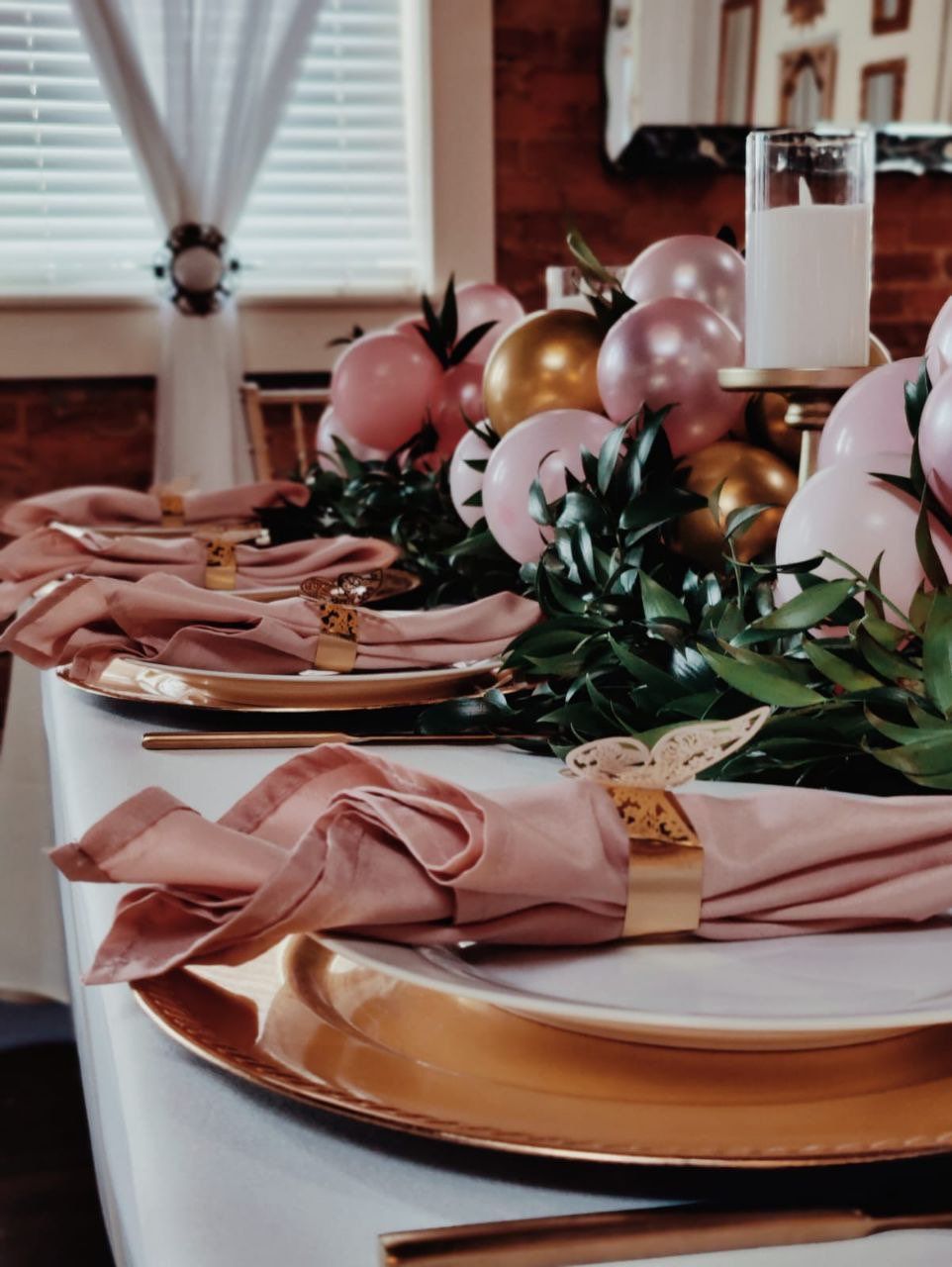 A table with plates and napkins and balloons on it
