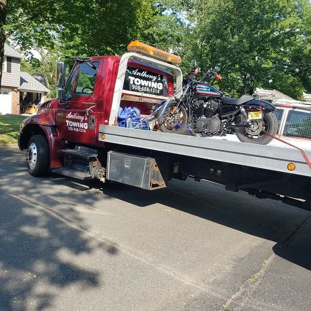 A towing truck with a motorcycle on the back of it