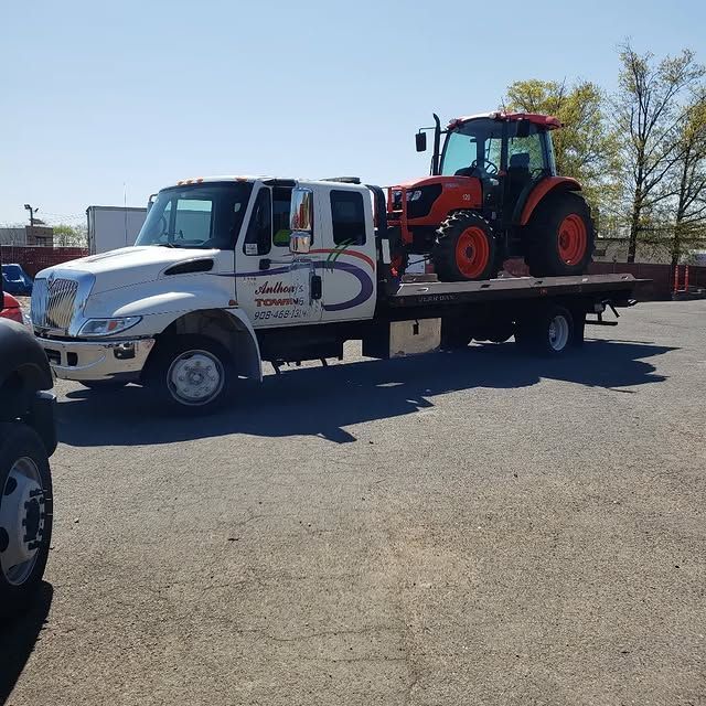A tow truck with a tractor on the back of it