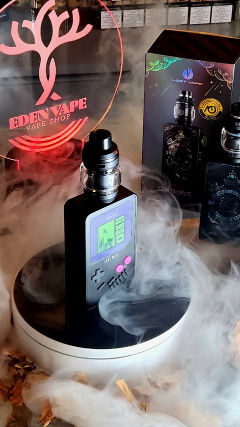 Una bottiglia di profumo è appoggiata su un tavolo e da essa esce del fumo.