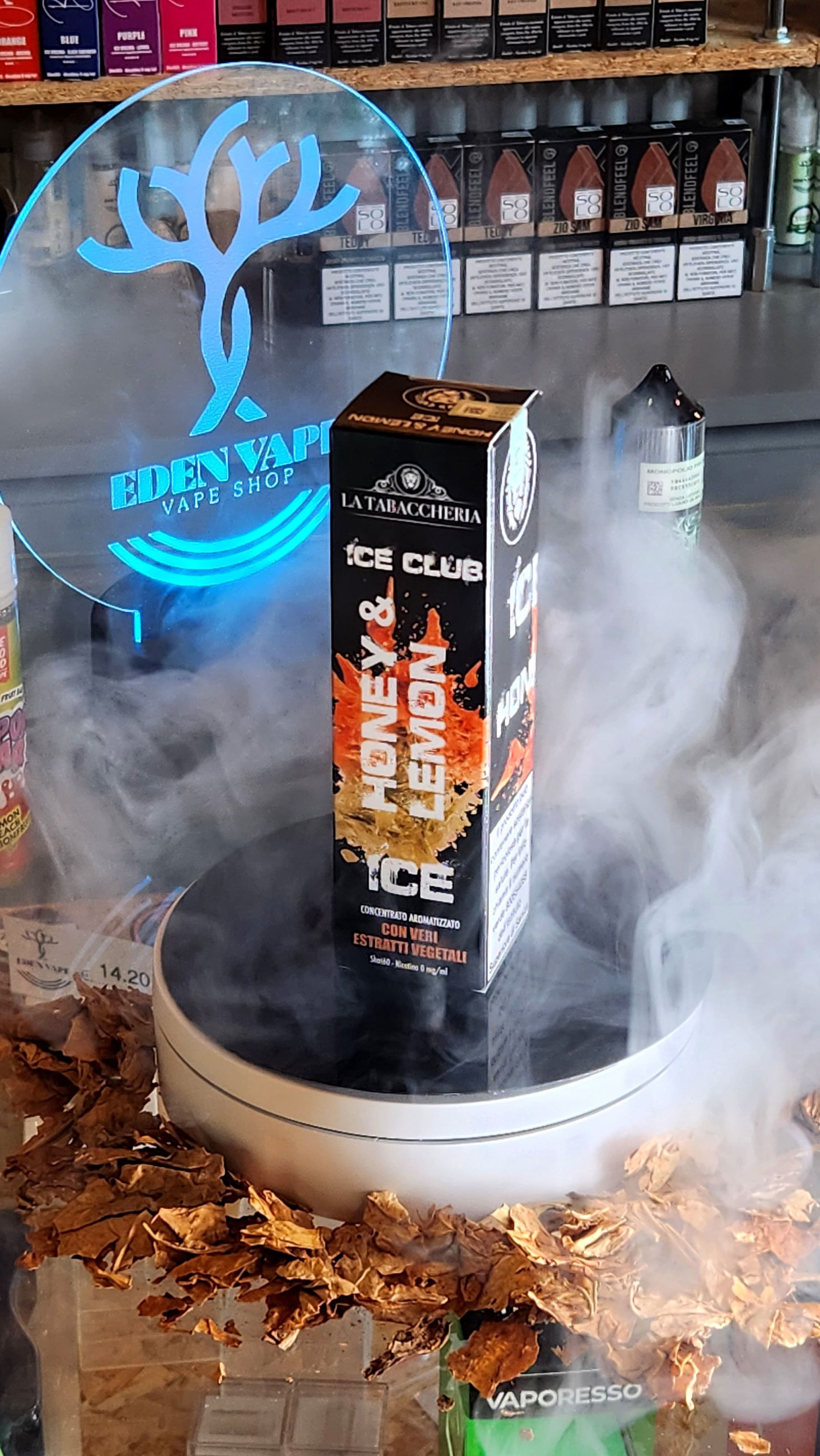 Una scatola di e-liquid al miele e limone è appoggiata su un tavolo e da essa esce del fumo.
