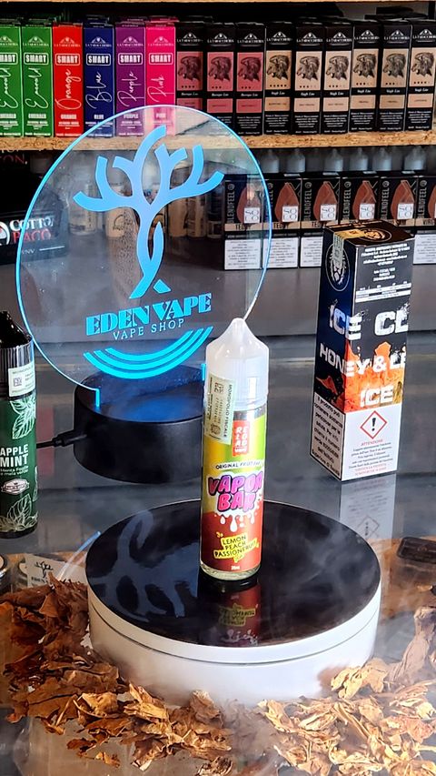 Una bottiglia di e-liquid è appoggiata su un tavolo in un negozio.