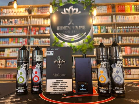 Un mucchio di bottiglie di e-liquid sono appoggiate su un tavolo in un negozio.