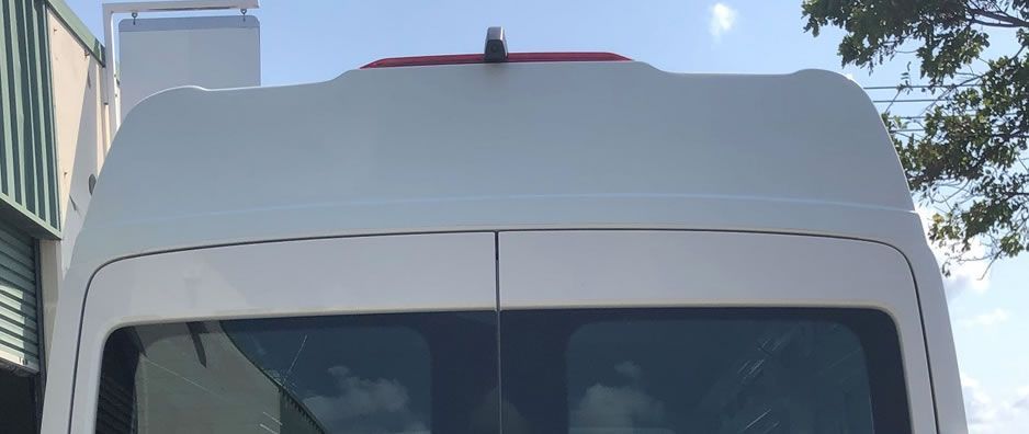 A white van is parked in front of a building.