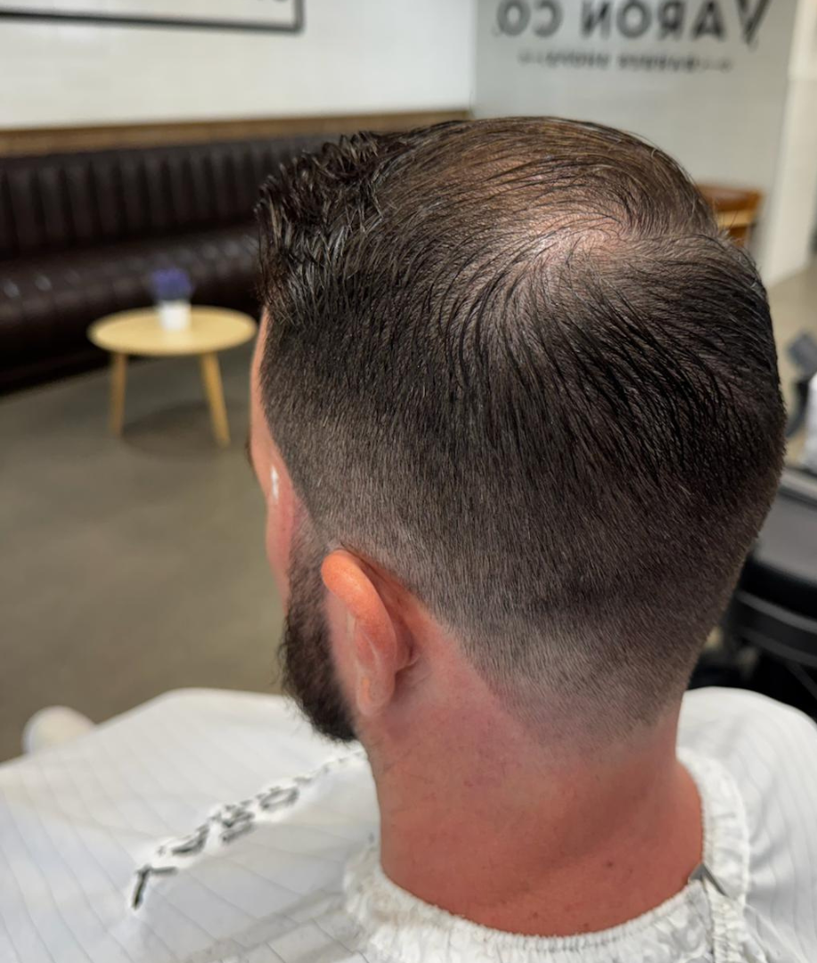 Man with short haircut and faded sides at a barber shop.