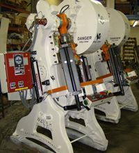 A row of machine sitting next to each other in a warehouse.