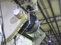 A large machine is hanging from the ceiling of a building.