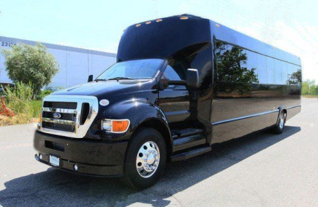 A black shuttle bus is parked on the side of the road.