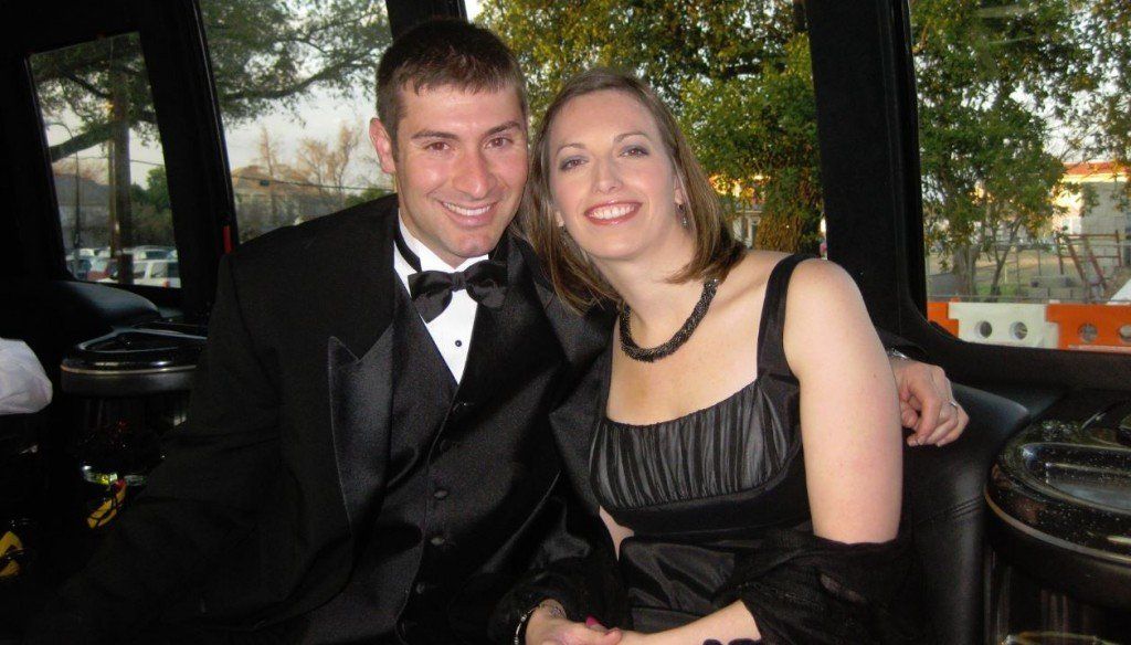A man in a tuxedo and a woman in a black dress are posing for a picture.