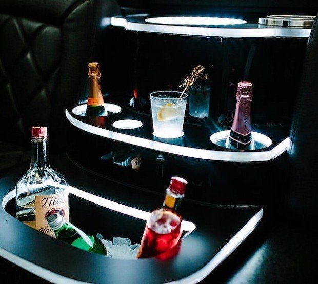 A bottle of tito 's sits on a shelf with other bottles