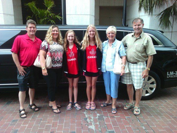 A group of people standing in front of a limo that says limousine
