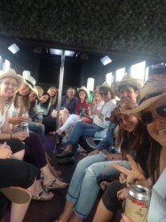 A group of women wearing cowboy hats are sitting on a bus.