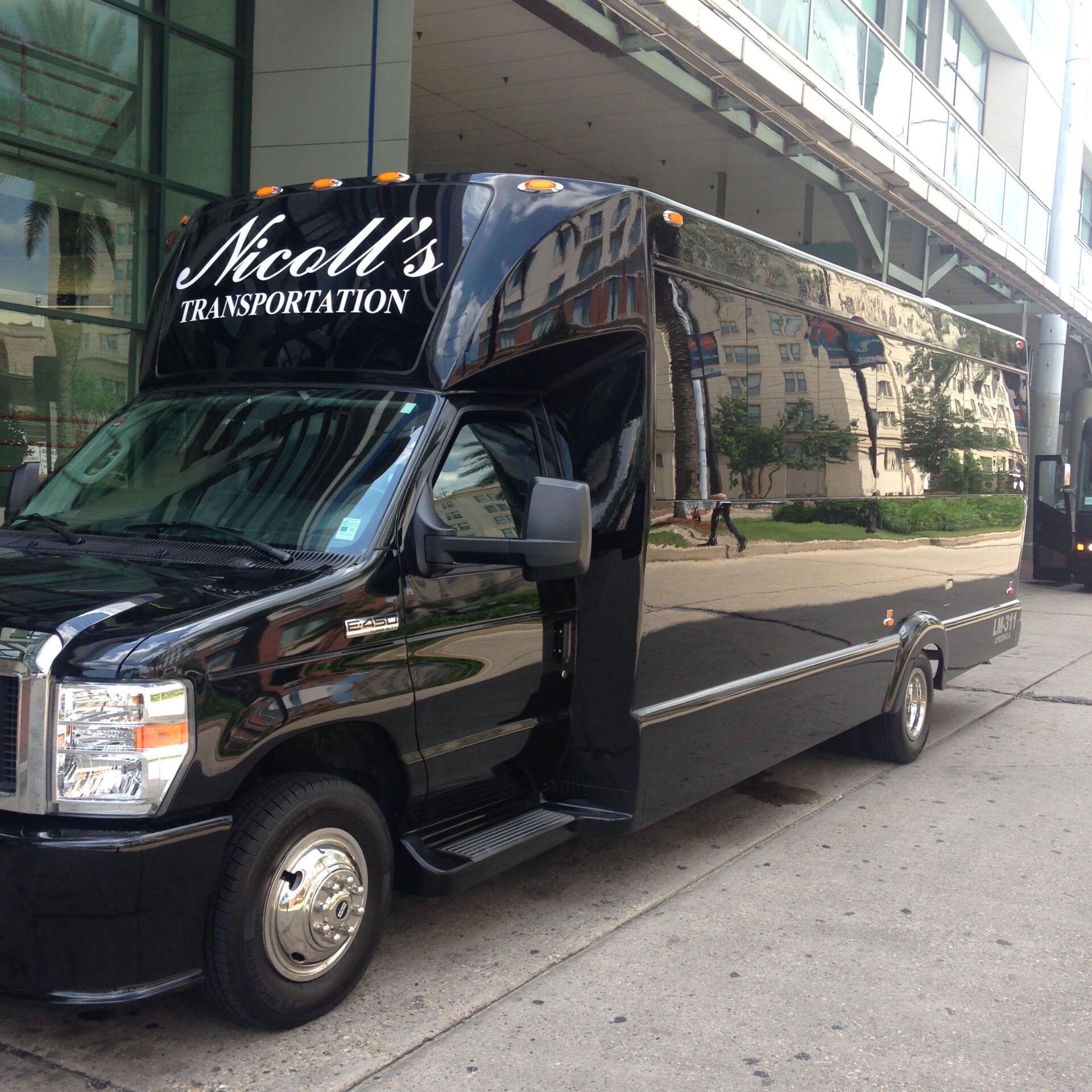 A nicole 's transportation van is parked in front of a building