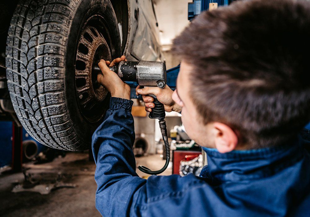 Man Replacing The Car Tire — Hagerstown, MD — Guaranteed Truck & Auto Repair