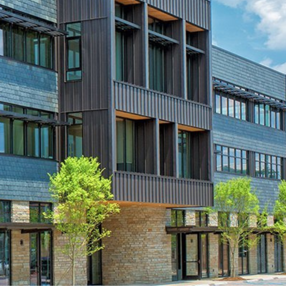 A large building with a lot of windows and trees in front of it
