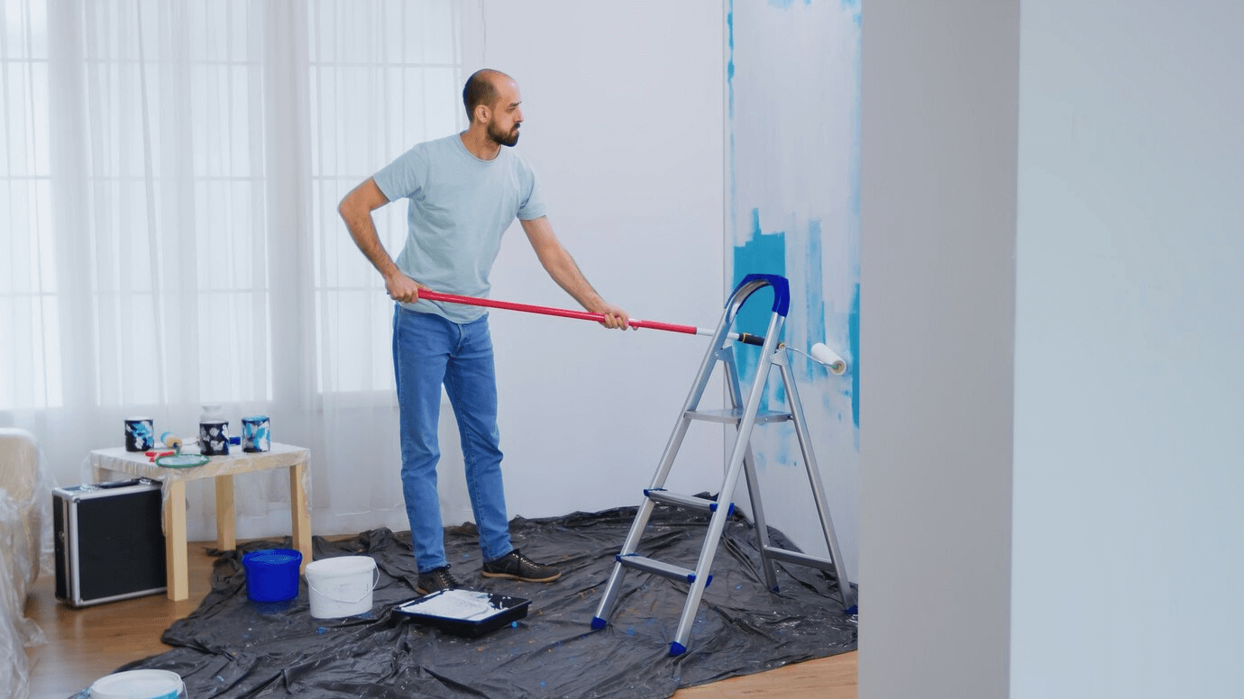 man painting the wall blue