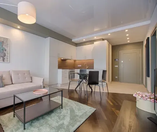 A living room with a couch , coffee table , dining table and chairs.