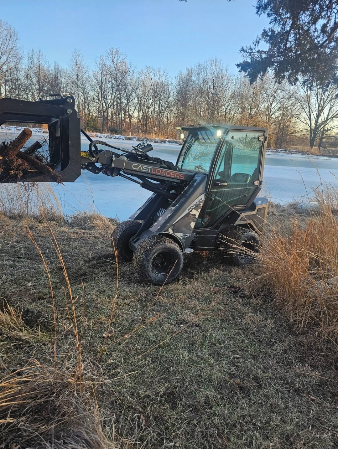 A small tractor is sitting in the middle of a field.