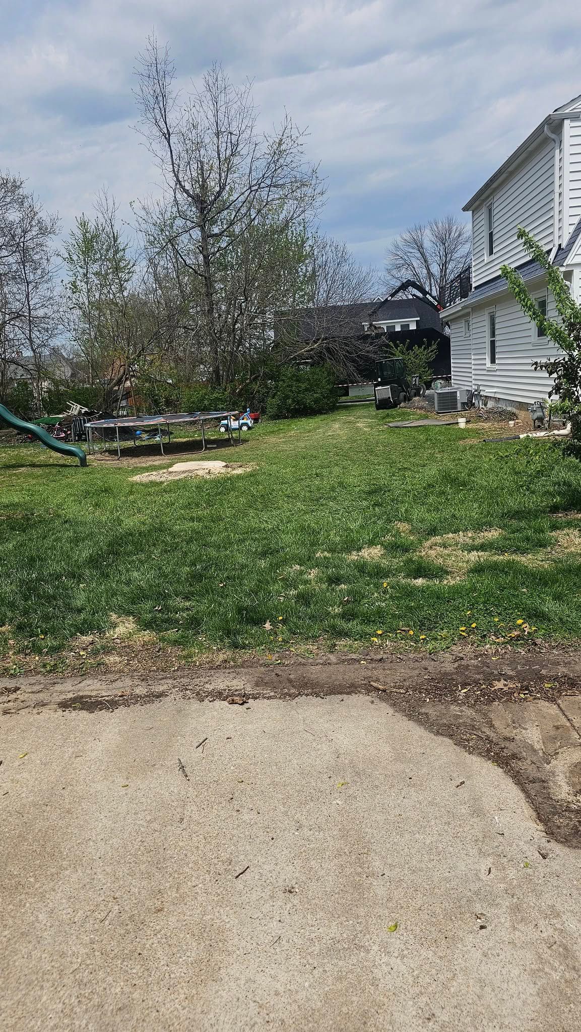 A white house is sitting in the middle of a lush green field.