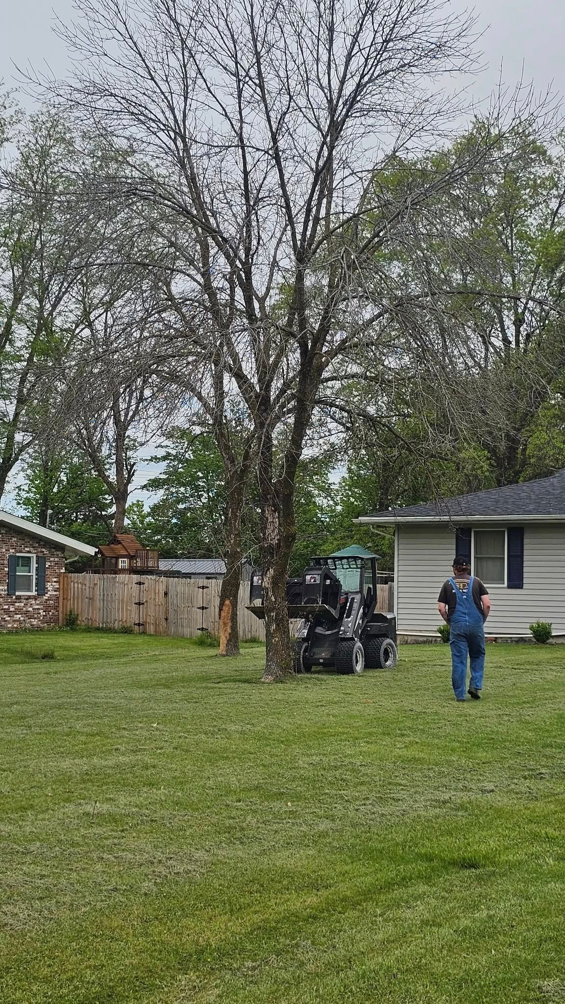 A man is mowing a lawn in front of a house.