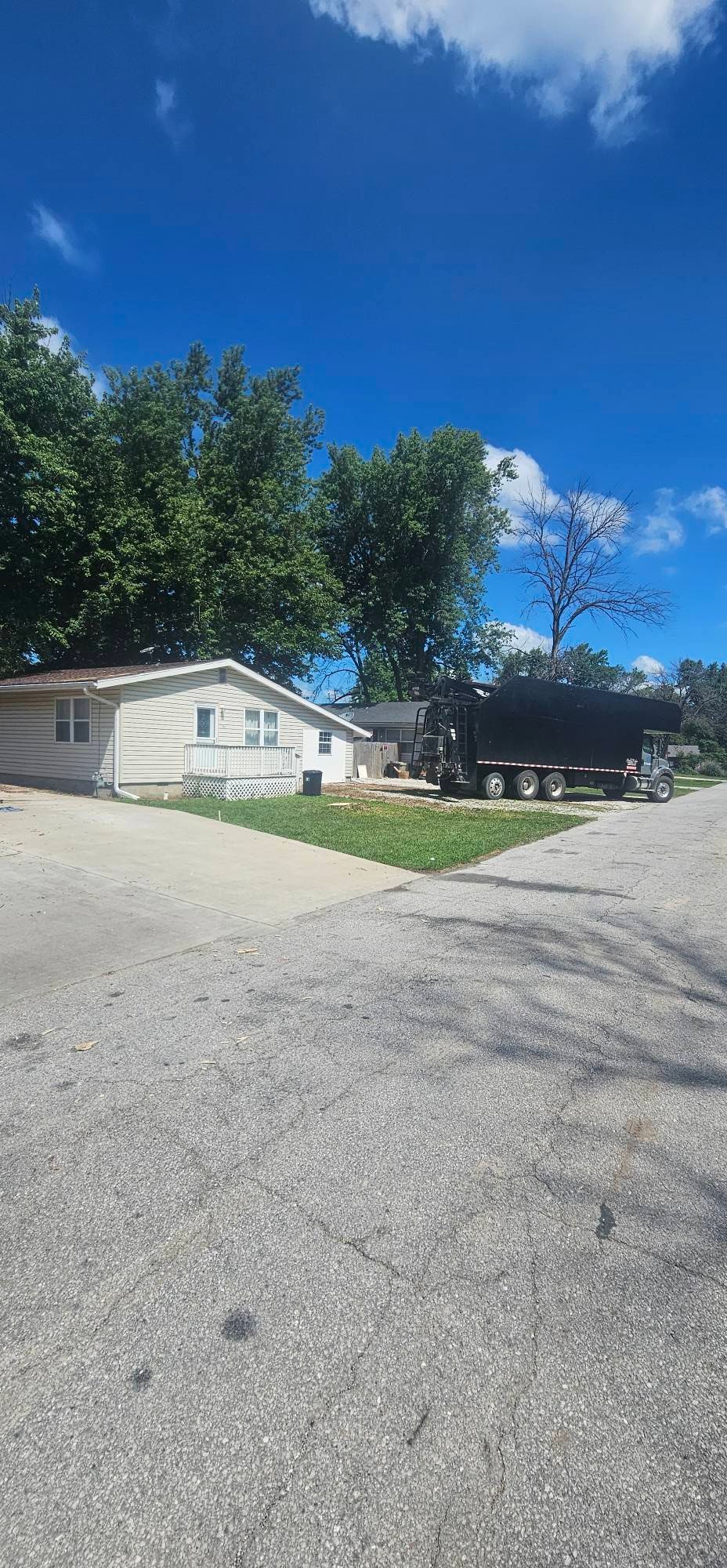 A trailer is parked in front of a mobile home on a sunny day.