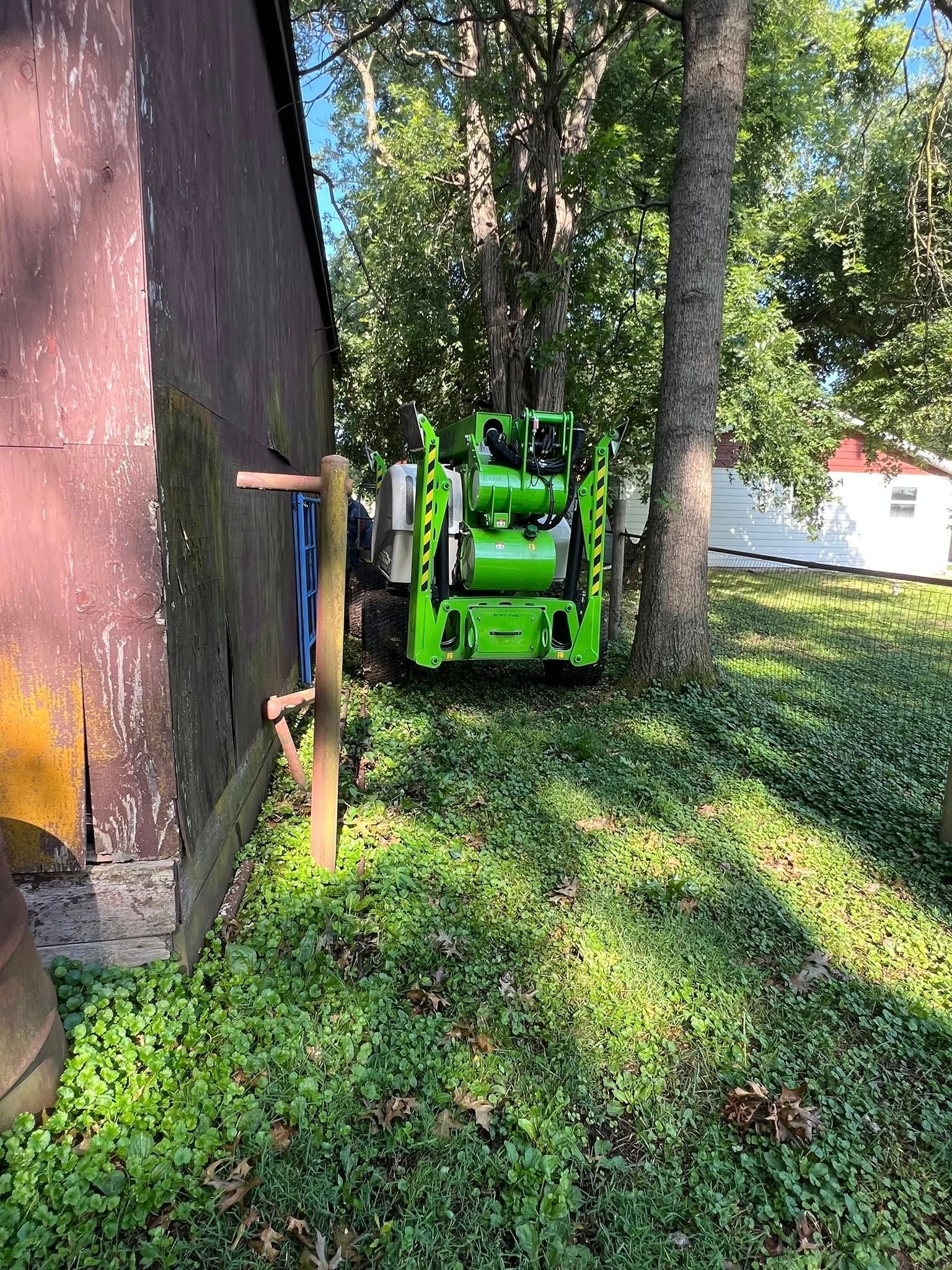 A green machine is parked in front of a brown building.