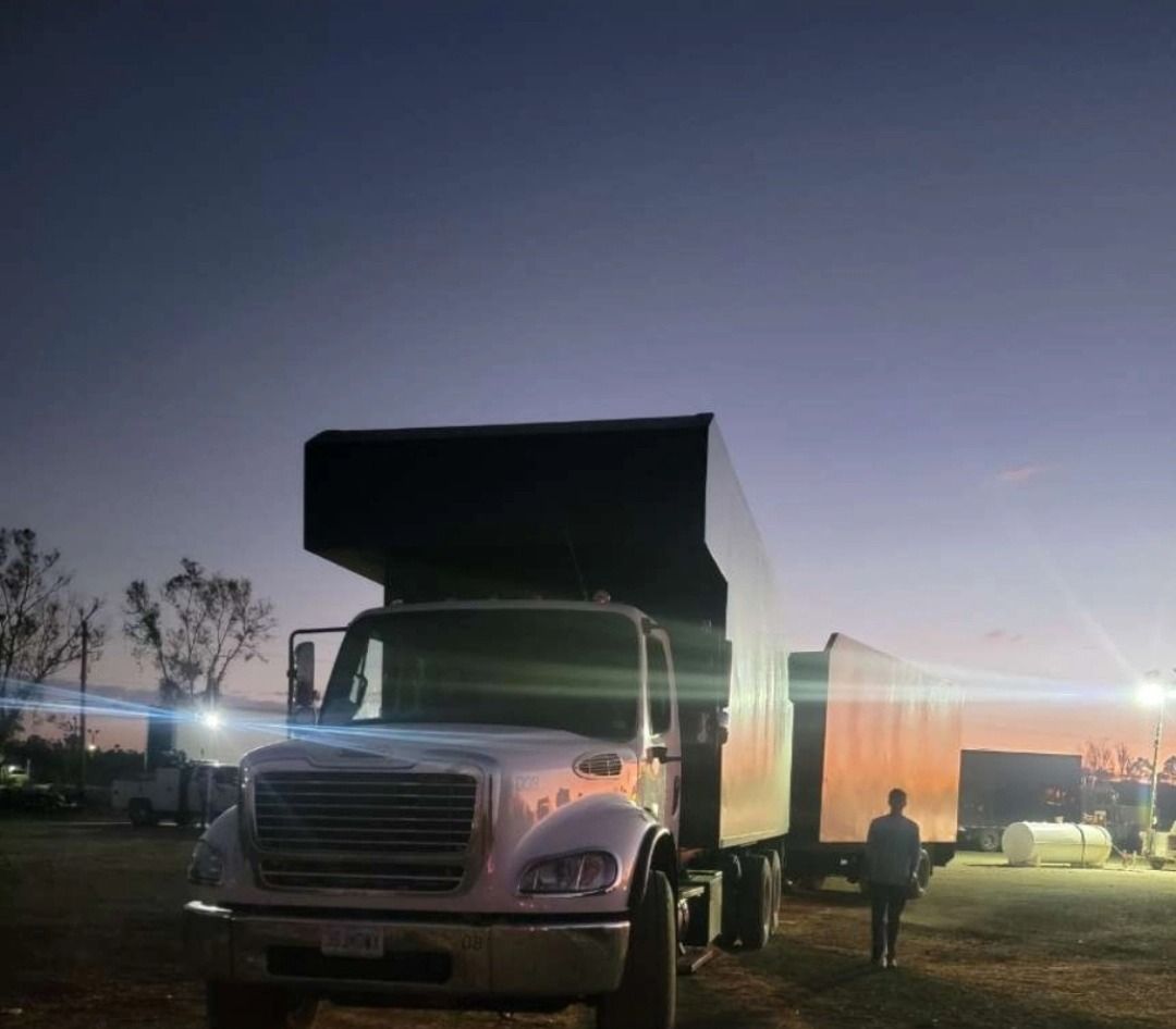 A truck is parked in a parking lot at night.
