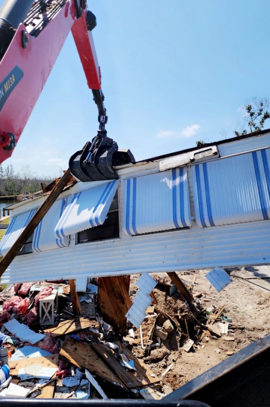 A yellow cat excavator is demolishing a building