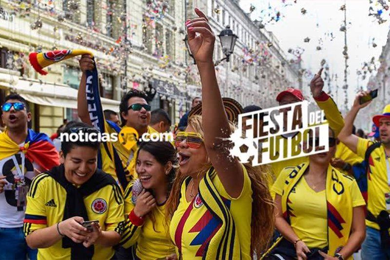 A group of people wearing yellow shirts are standing on a street.