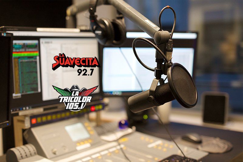 A microphone is sitting in front of a screen that says suavecita 92.7