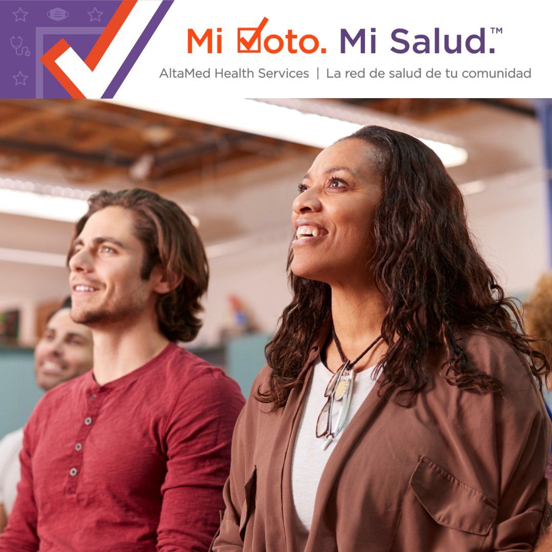 A group of people sitting in front of a sign that says mi moto mi salud