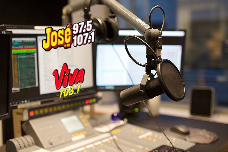 A microphone is in front of a screen that says jose 107.1