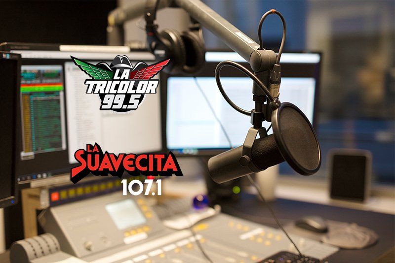 A microphone is sitting in front of a sign that says la suavecita 107.1