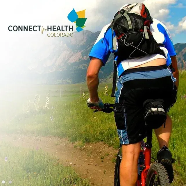 A man riding a bike with a connect health colorado logo in the background